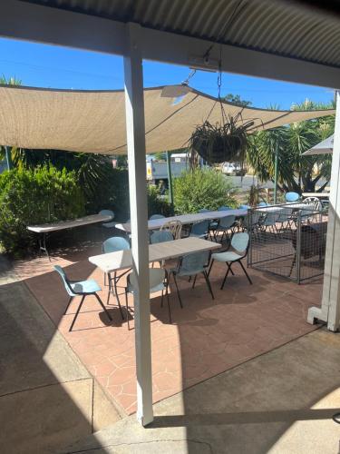 a patio with tables and chairs and an umbrella at Walla Walla Hotel Motel in Walla-Walla