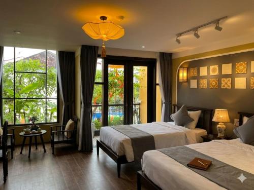 a hotel room with two beds and a large window at Hoianan Boutique Hotel in Hoi An