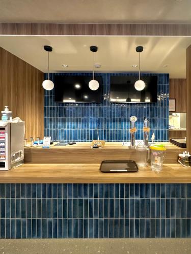 a kitchen with a counter with blue tiles at My Ecolodge in Kutchan