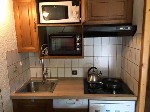 a small kitchen with a sink and a microwave at Apartment Clos du Savoy in Chamonix-Mont-Blanc