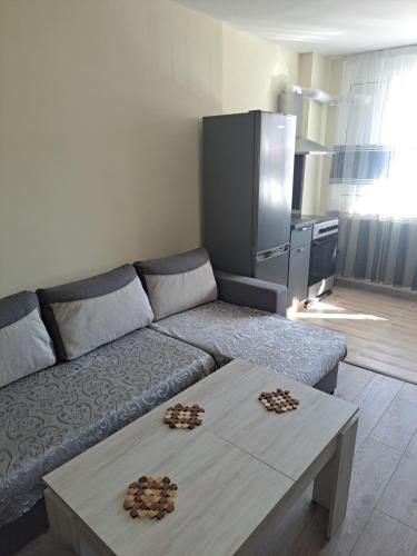 a living room with a couch and a table at Удобство - 3 in Petrich
