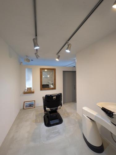 a office with a black chair in a room at Hostel x Hair ie in Hadano
