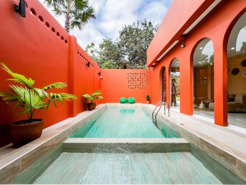 a swimming pool in a house with an orange wall at เพลาวิลล่า in Langu