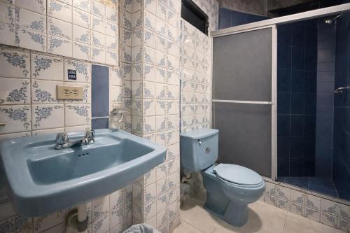 a bathroom with a blue sink and a toilet at Viena Internacional B&B - Rooftop in Quito