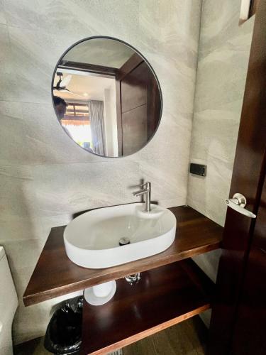ein Badezimmer mit Waschbecken und Spiegel in der Unterkunft Seajour Beach Resort in Ginatilan