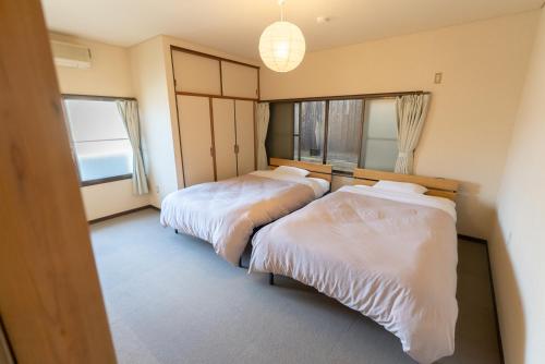 a bedroom with two beds and a large window at The M HIGASHIMACHI in Nakatsugawa