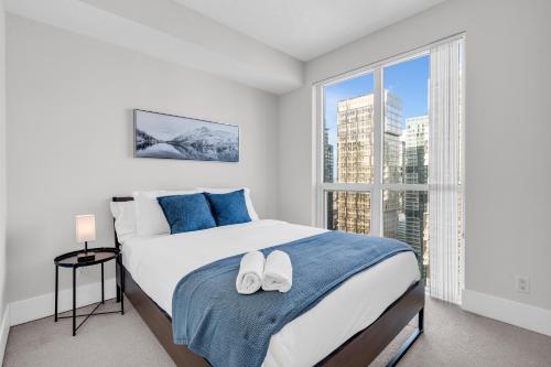 a bedroom with a bed and a large window at Eleve Toronto Residences in Toronto