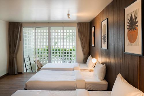 a hotel room with two beds and a large window at SOL HOUSE kohlarn in Ko Larn
