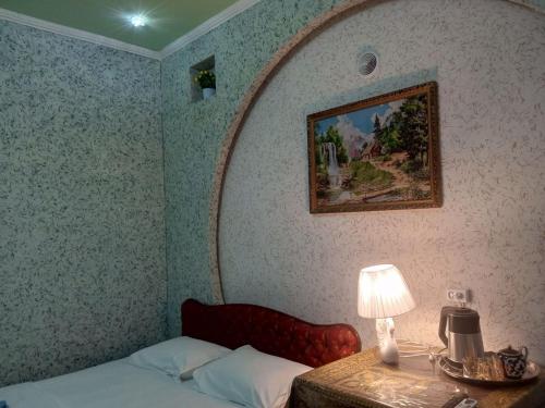 a bedroom with a bed and a table with a lamp at Sohibqiron boutique in Bukhara