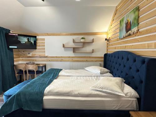 a bedroom with a bed and a tv on a wall at Vila Arina -Private Retreat in Voronet