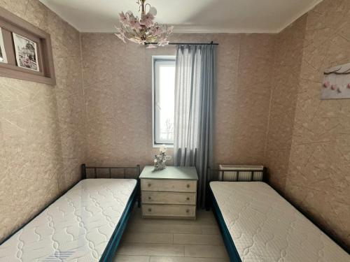 two twin beds in a room with a window at Marina Apartments in Gudauri
