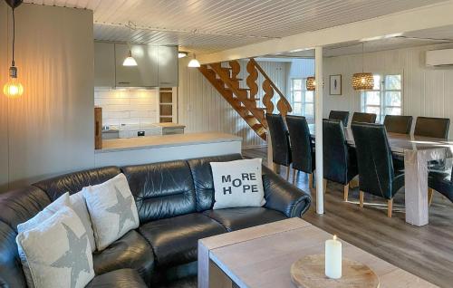 a living room with a leather couch and a table at Holiday Home Froidal Rømø in Toftum