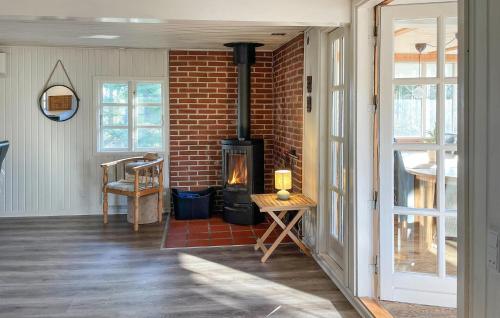 a living room with a brick wall and a wood stove at Holiday Home Froidal Rømø in Toftum