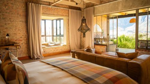 a living room with a couch and windows at De Zeven Guest Lodge in Stellenbosch