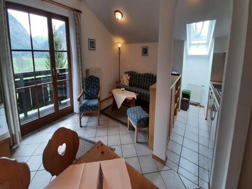 a living room with a couch and a table and chairs at Beautiful lodging in the Alps near Bayrischzell in Bayrischzell