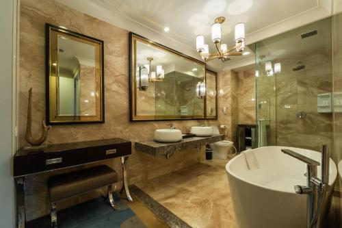 ein Badezimmer mit Badewanne, zwei Waschbecken und einer Badewanne in der Unterkunft I Hotel Batam in Nagoya