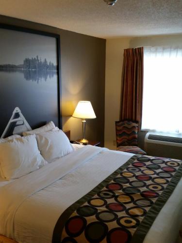 a hotel room with a bed and a window at Super 8 by Wyndham Brockville in Brockville