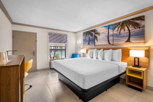 a bedroom with a large bed with a large window at Days Inn by Wyndham Florida City in Florida City