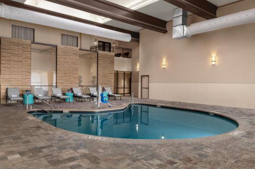 a pool in the lobby of a hotel with tables and chairs at Doubletree By Hilton Lubbock - University Area in Lubbock