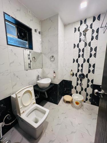 a bathroom with a toilet and a sink at Hotel Nisha in Mahabaleshwar