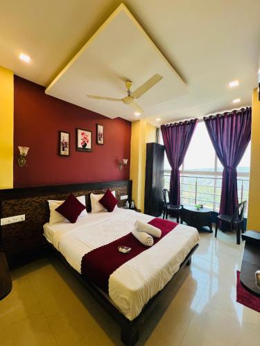 a bedroom with a large bed with purple walls at Hotel Nisha in Mahabaleshwar
