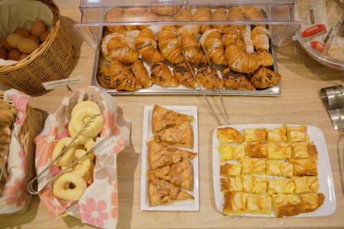 a table topped with trays of pastries and other foods at Hotel Porta Nuova in Assisi