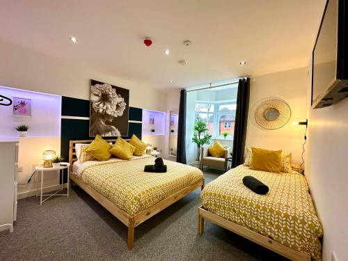 a bedroom with two beds with yellow and black stripes at Massive New 8 bedroom House Sleeps up to 21 - Accepts Groups - Great Location - FREE Parking - Fast WiFi - Smart TVs - sleeps up to 21 people - Close to Bournemouth & Poole Town Centre & Sandbanks in Bournemouth