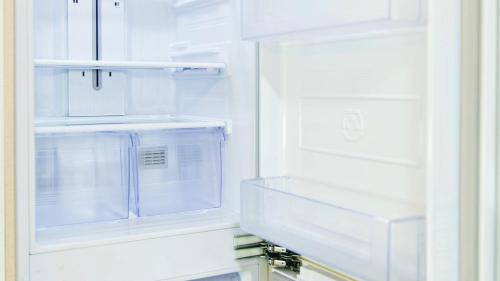 an empty refrigerator with its door open in a kitchen at Busan Ieumjae Seomyeon Station in Busan