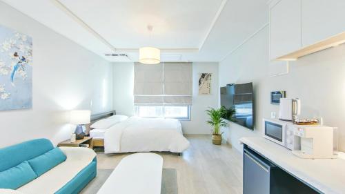 a white room with a bed and a couch at Busan Ieumjae Seomyeon Station in Busan