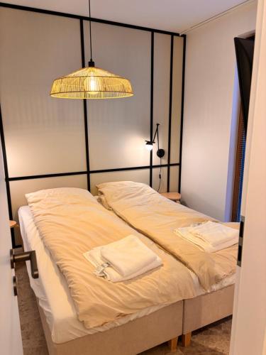a bedroom with a bed with a lamp and towels on it at Przystań NADOLE- APARTAMENT in Nadole