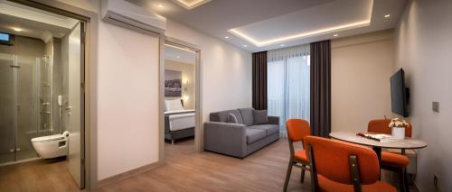 a room with a table and a chair and a couch at Rai Premium İstanbul in Istanbul