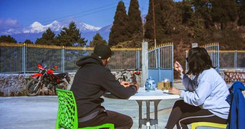 a group of people sitting at a table with a motorcycle at Hotel Himalayan Vista in Pāti Bhanjyāng
