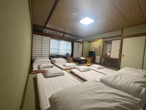 a room with a bunch of beds in it at Ishicho in Kyoto