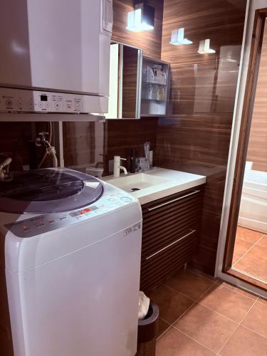 a kitchen with a dishwasher and a sink in it at Suite Terrace Ishigakijima in Ishigaki Island