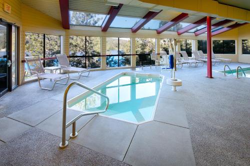 a swimming pool in a building with chairs and tables at Red Lion Templin's Hotel on the River in Post Falls