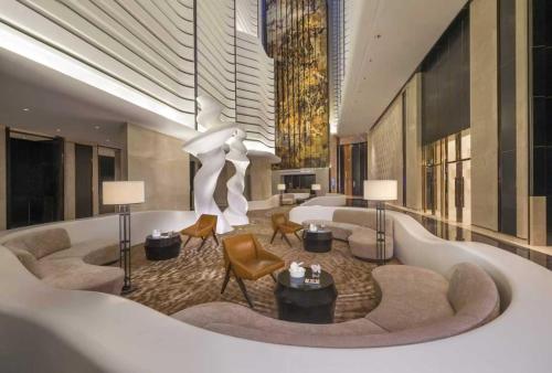 a hotel room with a lobby with a couch and chairs at Jumeirah Nanjing in Nanjing