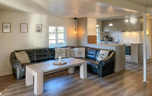 a living room with a leather couch and a table at Holiday Home Froidal Rømø in Toftum