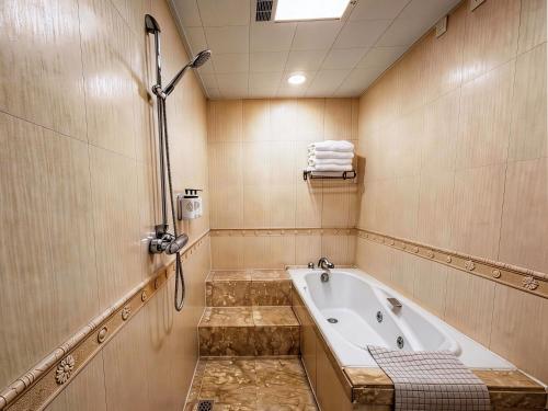 a bathroom with a tub and a shower at Grand Mercure Xian On Renmin Square in Xi'an
