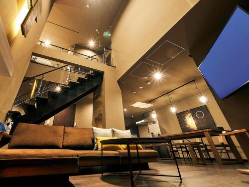 a living room with a couch and a staircase at Rakuten STAY VILLA Hakone Sengokuhara North Wing 102 with Massage chair, capacity of 10 persons in Hakone