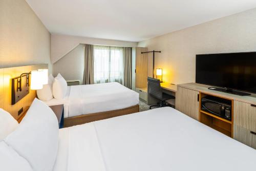 a hotel room with two beds and a flat screen tv at Comfort Inn in Edmundston