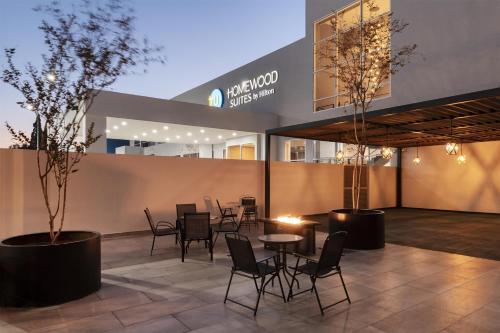 a patio with chairs and tables in front of a building at Homewood Suites By Hilton Saltillo in Saltillo