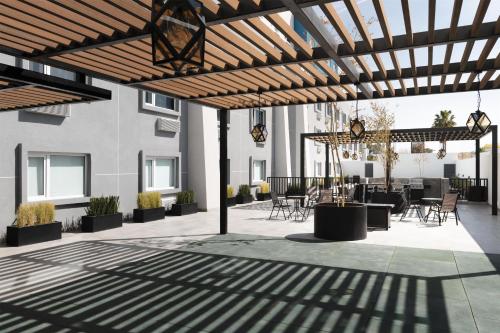 a patio with a wooden pergola with tables and chairs at Homewood Suites By Hilton Saltillo in Saltillo