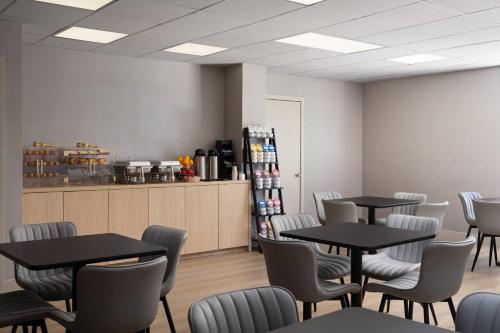 a dining room with tables and chairs and a counter at The Harrison Hotel Downtown Hollywood FL, an Ascend Collection Hotel in Hollywood