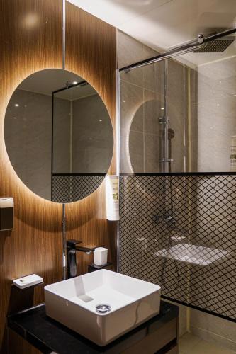 ein Badezimmer mit Waschbecken und Spiegel in der Unterkunft Embledon Hotel in Ansan