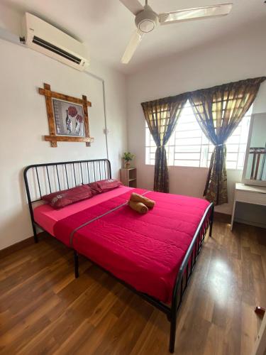 a bedroom with a large bed with a red blanket at Anggerik Camelia Homestay Apartment Ladang Tok Pelam FREE WIFI in Kuala Terengganu