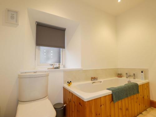 a bathroom with a tub and a toilet and a sink at Nanville in Beauly