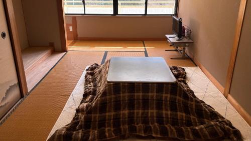 a room with a table with a laptop on the floor at 楽校うらしり in Uwajima