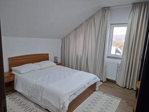a bedroom with a bed and a large window at Autentic Adorabil Apartment in Albeştii Pămînteni