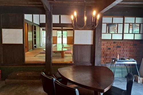a dining room with a wooden table and chairs at コテージフラミンゴ in Futtsu