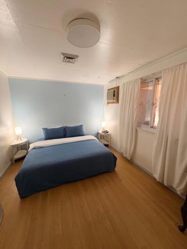 a bedroom with a blue bed and a window at A Pet Friendly Subic Bay Vacation Home in Olongapo